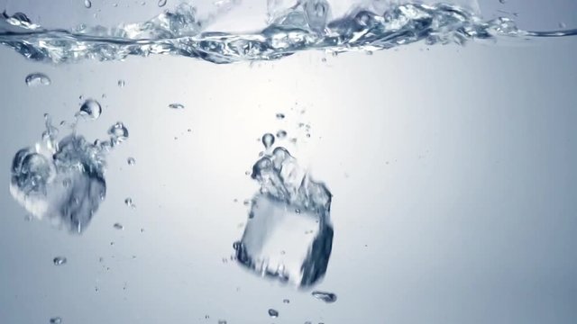 Slo-motion cubes falling through water. 120 fps.