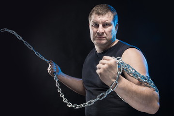 Brutal man actor gesticulates and grimaces on a black background.