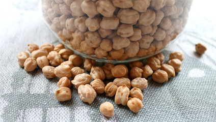 The dry chickpeas in a glass jar on the kitchen table