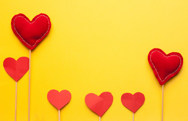 Fototapeta na wymiar red hearts on a stick, yellow background