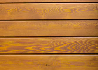 Natural wooden orange background, rough texture of hardwood planks for floors and walls in the construction of the house