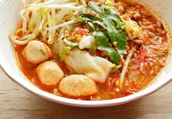 rice noodle with pork ball in tom yum spicy soup topping raw bean sprout on bowl