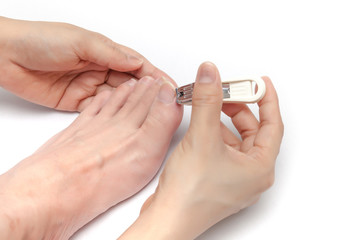 Using nail cutter to cut toenails on white background isolated