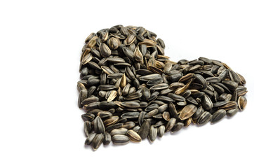 Sunflower seed arrange in heart shape on white background isolated with copy space