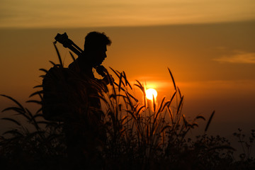 Fototapeta premium Silhouette of a young who like to travel and photographer