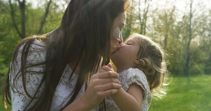 On a sunny day a mother and her baby girl immersed in the organic nature, play and laugh. Mom and baby girl having fun a lot and show love towards each other. love of a family.
