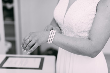 Fototapeta premium Bridal preparation, bride putting on jewelry, focus on bracelet 