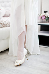 Bride dresses shoes before the wedding ceremony