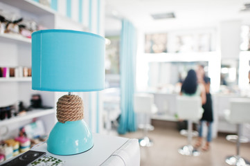 Turquoise desk lamp with decor cord on beauty studio.
