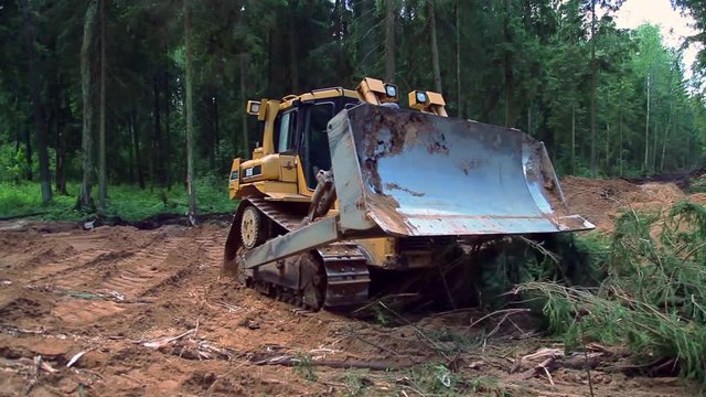 Large bulldozer evens construction site. Live action.
