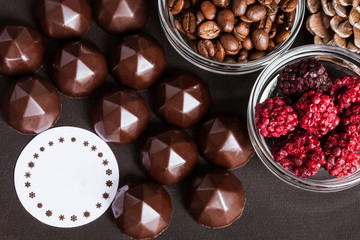 Chocolate sweets, coffee beans, dry raspberries background