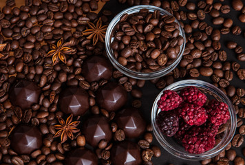 Chocolate sweets, coffee beans, dry raspberries background