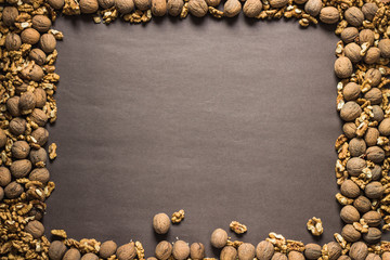 Frame made of walnuts on brown paper background