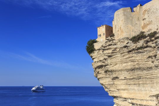Old citadel atop cliffs with cruise ship anchored off shore, Bonifacio, Corsica, France, Mediterranean
