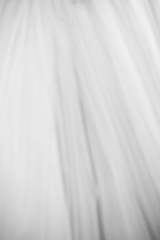 Obraz premium White long bridal dress with details of lace in showroom, vertical black and white