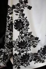 White long evening dress with black lace details, shallow focus,