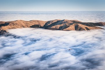 Paraglider over dense fog