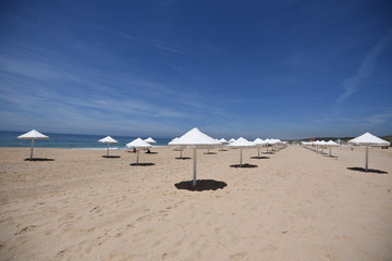 Fototapeta na wymiar Sun umbrellas on a beach, Praia do Meco, Portugal