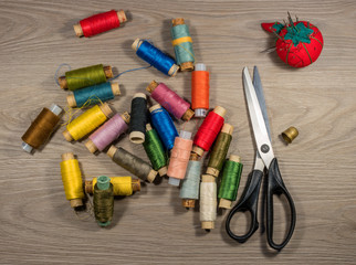 Sewing tools and accessories on wood background.