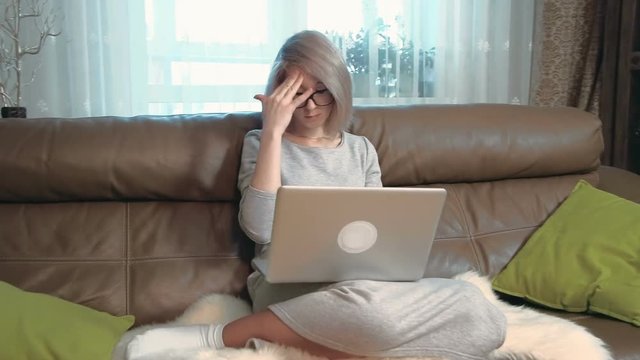 Tired young woman using a laptop computer and has a headache
