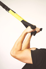 TRX. Male hands with fitness TRX straps in gym.