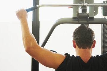 Fototapeta na wymiar Man in a gym doing weight lifting