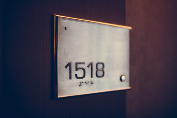 Number table on the door of room in the hotel, shallow focus