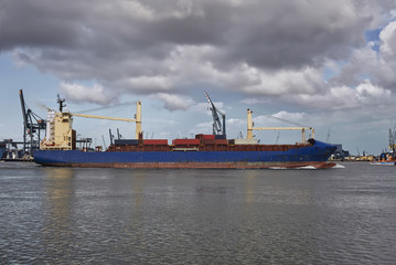 Panoramic image of a container ship passing cranes in Rotterdam