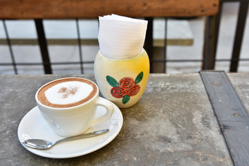 hot coffee cup on rock table on brown background