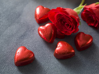 Valentines day background with chocolate hearts and red roses