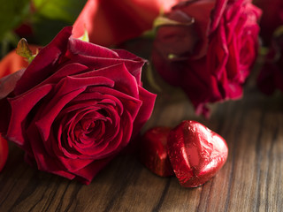 Chocolate hearts, red roses bouquet with red ribbon