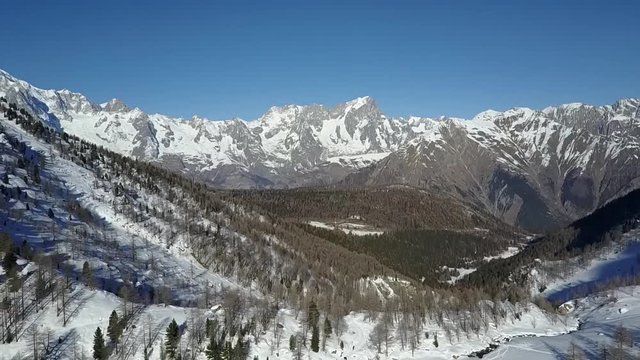 Escursionista attraversa piccolo ponte in legno in vista del rifugio Arbolle in Valle d'Aosta