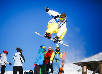 Jumping snowboarder on blue sky background