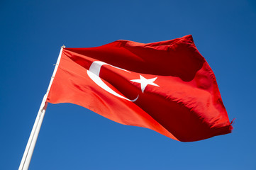Turkish flag flying in bright blue sky