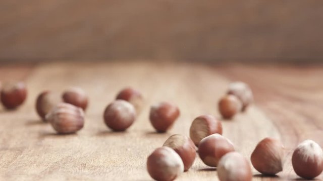 unpeeleed hazelnuts falling on wood table in slow motion, 180fps prores footage