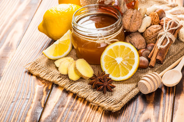 Obraz na płótnie Canvas Honey comb, fresh lemon and ginger on a wooden table