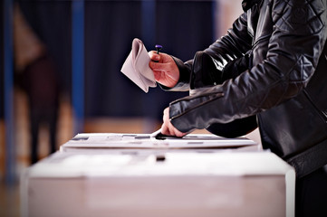 Hands with a stamp casting a vote
