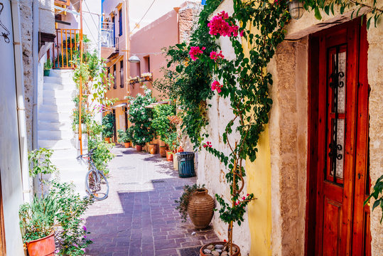 Colorful streets of old Chania town with blooming flowers and ancient stone, Crete, Greece.