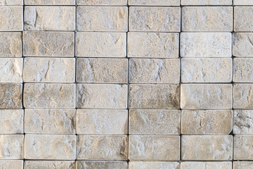 Texture of repeating small gray stones in the wall
