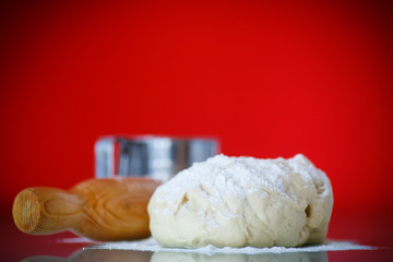 yeast dough with a wooden rolling pin
