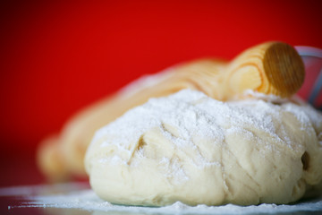 yeast dough with a wooden rolling pin
