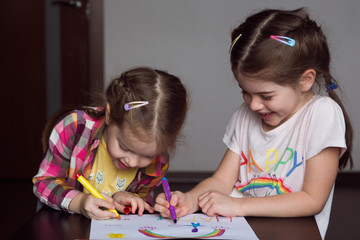 Happy cute kids draw  rainbows and write the word happiness, small  artists paint  rainbow