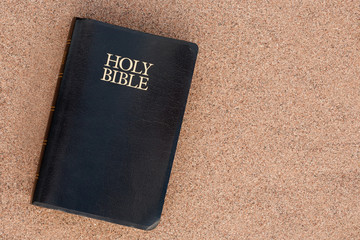 Holy Bible on sand. Top down view.