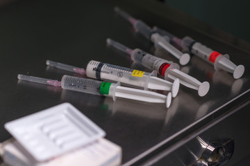 Siringhe monouso su un mobiletto di metallo pronte per essere usate 