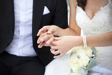 Obraz na płótnie Canvas Bride put the wedding ring on the groom