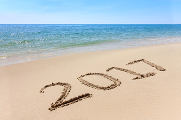 Year 2017 written at the sand beach with sea wave water