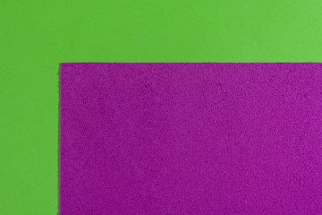 Fototapeta premium Eva foam ethylene vinyl acetate sponge plush pink surface on apple green smooth background