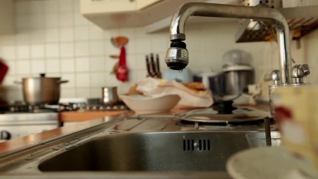 Dettaglio ambiente cucina con rubinetto gocciolante.