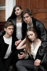 Young elegant trendy friends outdoors, wearing black and white clothing