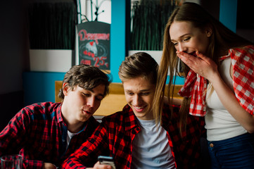 Group of young friends hanging out at a coffee shop. Young men and women meeting in a cafe having fun and drinking coffee. Lifestyle, friendship and urban life concepts.